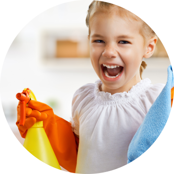 a child laughing and holding cleaning supplies
