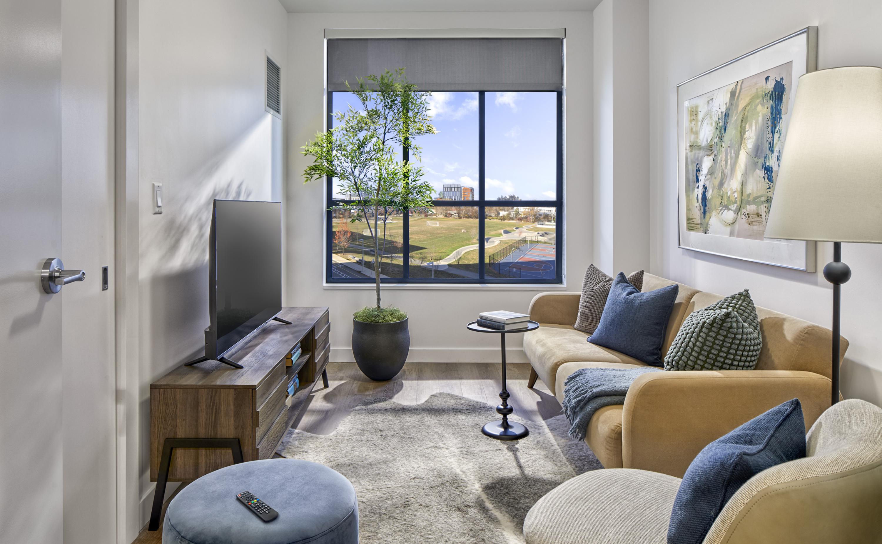 shared living area with mock unit furniture, large window views, and hard flooring