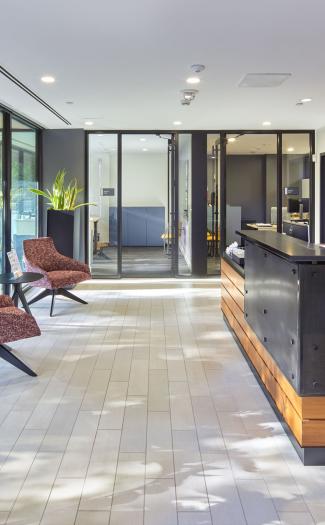 A Harvard University Housing Property Management Office with a trademark Harvard crimson wall, receptionist desk, and large windows,