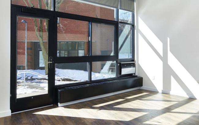 The interior of the Solder's Field building with many windows and a glass door, in addition to an air conditioning unit. 