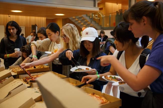 Harvard graduate students at an event, getting free food and pizza with their peers