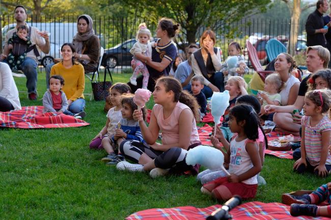 A crowd of residents sitting on the lawn at a GCP event