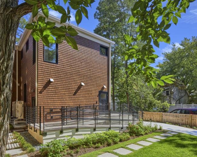 The rear view of 13 Kirkland, with an accessibility ramp leading to the rear entry and porch area