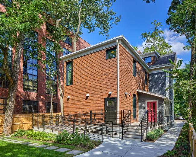 The back of 13 Kirkland: a newly renovated building with a bright red door and lush greenery