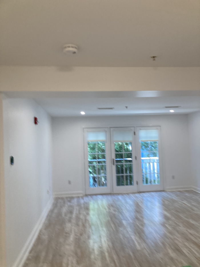 living room area with large windows, wood flooring