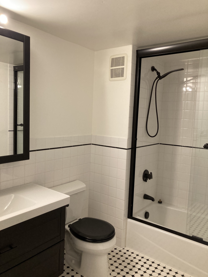 bathroom with black and white tile and black fixtures. 