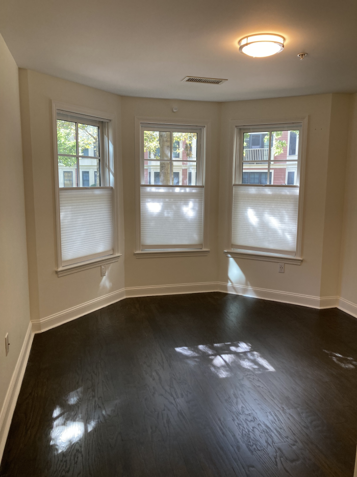 Bedroom with bay windows and dark wood flooring