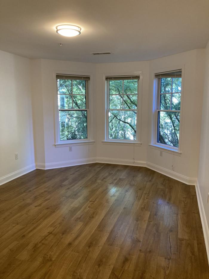 Bedroom with wood flooring and bay windows