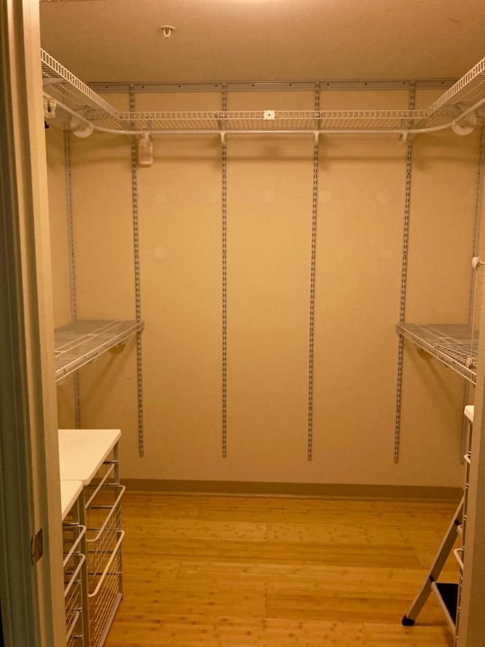 Large walk-in closet with built in shelving and wood flooring