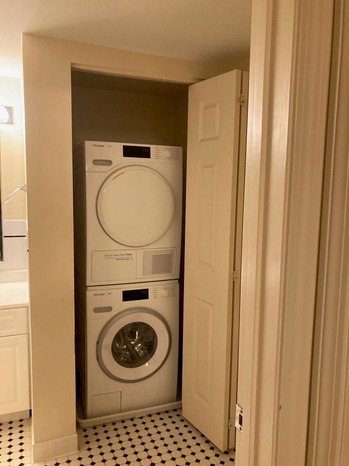 Open laundry closet, stacked washer and dryer