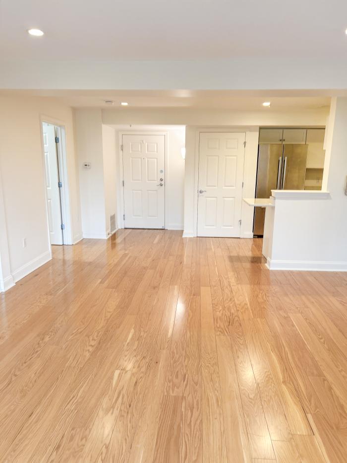 The view of the living room facing the kitchen, with hardwood flooring