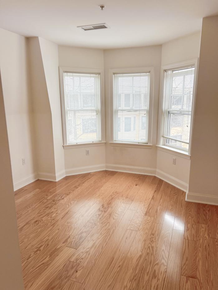 A bedroom of 173 401 - bright bay windows and hardwood flooring