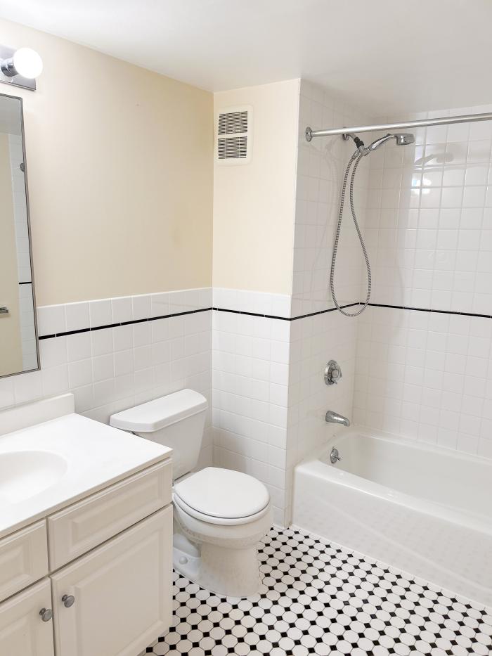 173 402 bathroom with white tile and a white toilet, tub, and sink.