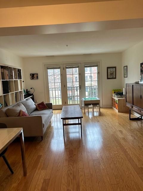 hardwood floors in the living room, with large windows letting in plenty of natural light