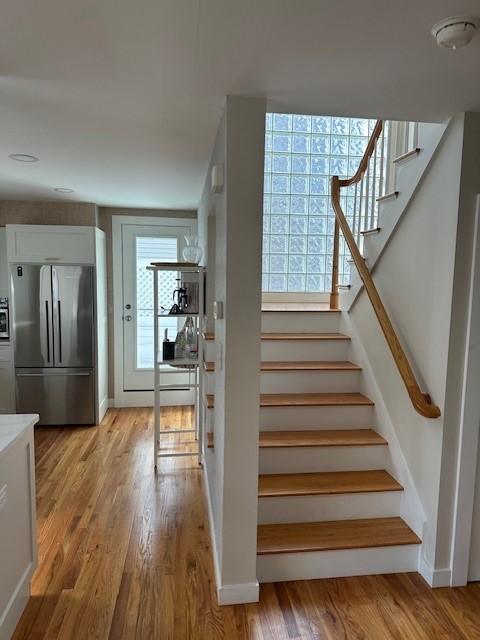 stairs off the kitchen with hardwood floors