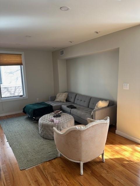living room area with a small cutout and hardwood floors