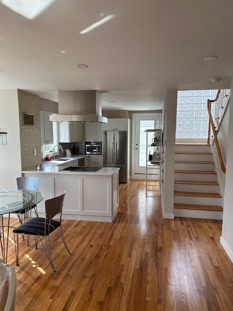 kitchen area with hardwood floors and stainless steel appliances. Open concept.