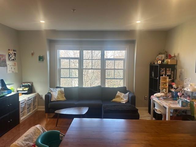 living and dining area with large windows, recessed lighting, and hard flooring.