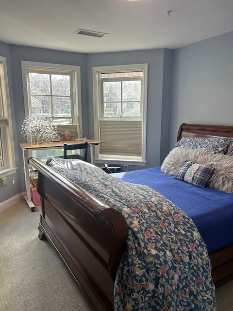 Secondary bedroom with bay windows, light blue wall paint, and carpeted flooring