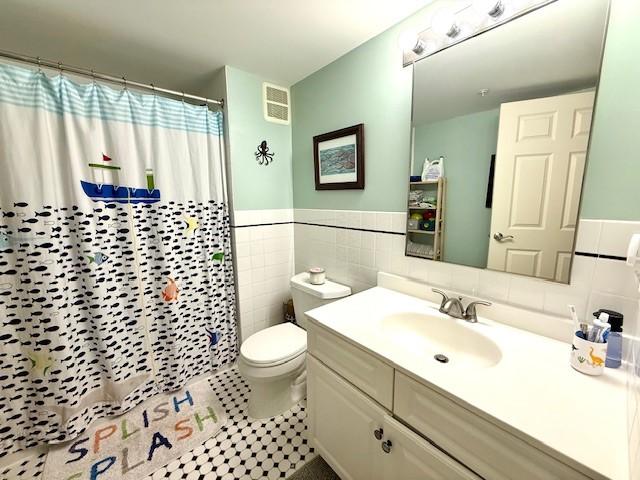 Second bathroom with spacious vanity, tile flooring, bathtub/shower, toilet