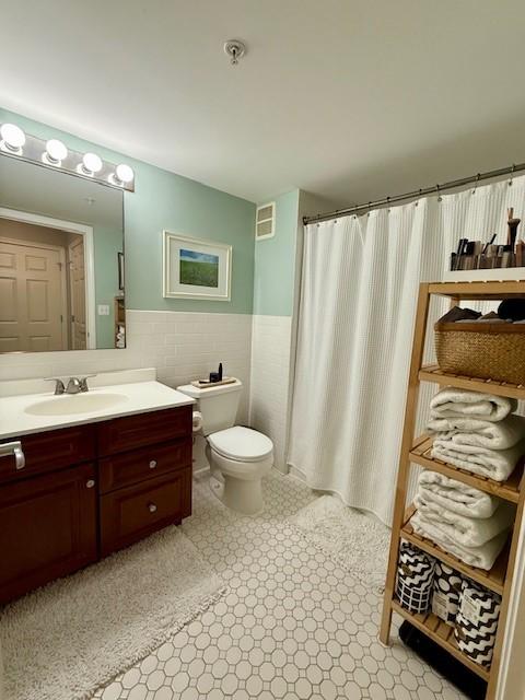 Primary bathroom with large vanity, tile flooring, tub/shower, toilet
