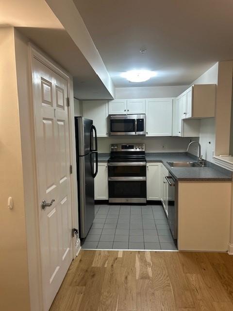Kitchen with white cabinetry and stainless steel appliances