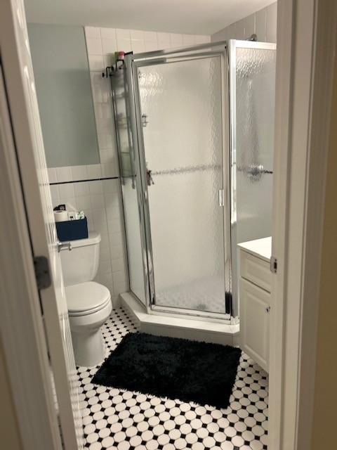 secondary bathroom with stand up shower and tiling
