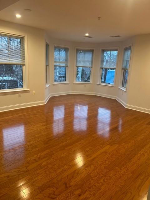 Combined living and dining area with hard flooring, bay windows, and overhead lighting