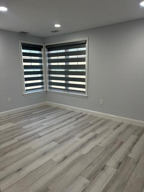 third bedroom with hard flooring and large windows with blinds