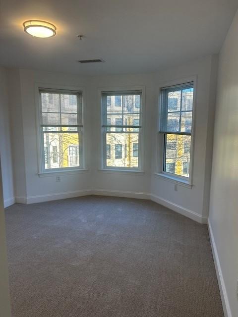 Second bedroom with carpet flooring and bay windows