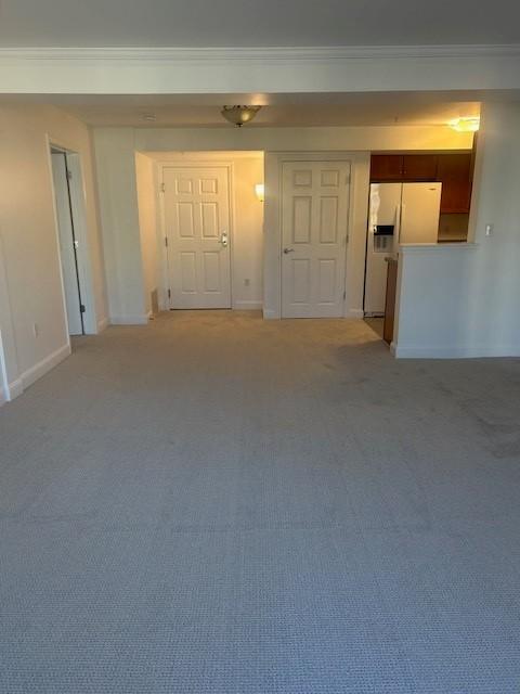 combined living and dining area facing the kitchen, with carpeted flooring
