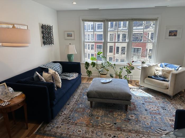 Combined living room and dining area with large sunny windows and hard flooring