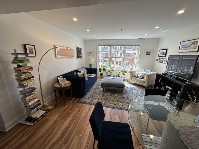 Combined living room and dining area with large sunny windows and hard flooring