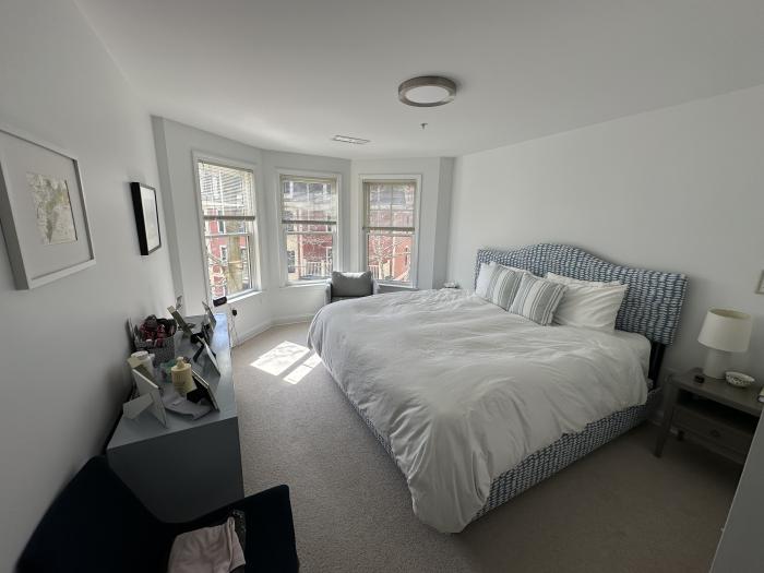 Bedroom with 3-paneled bay windows, carpeting, and overhead lighting