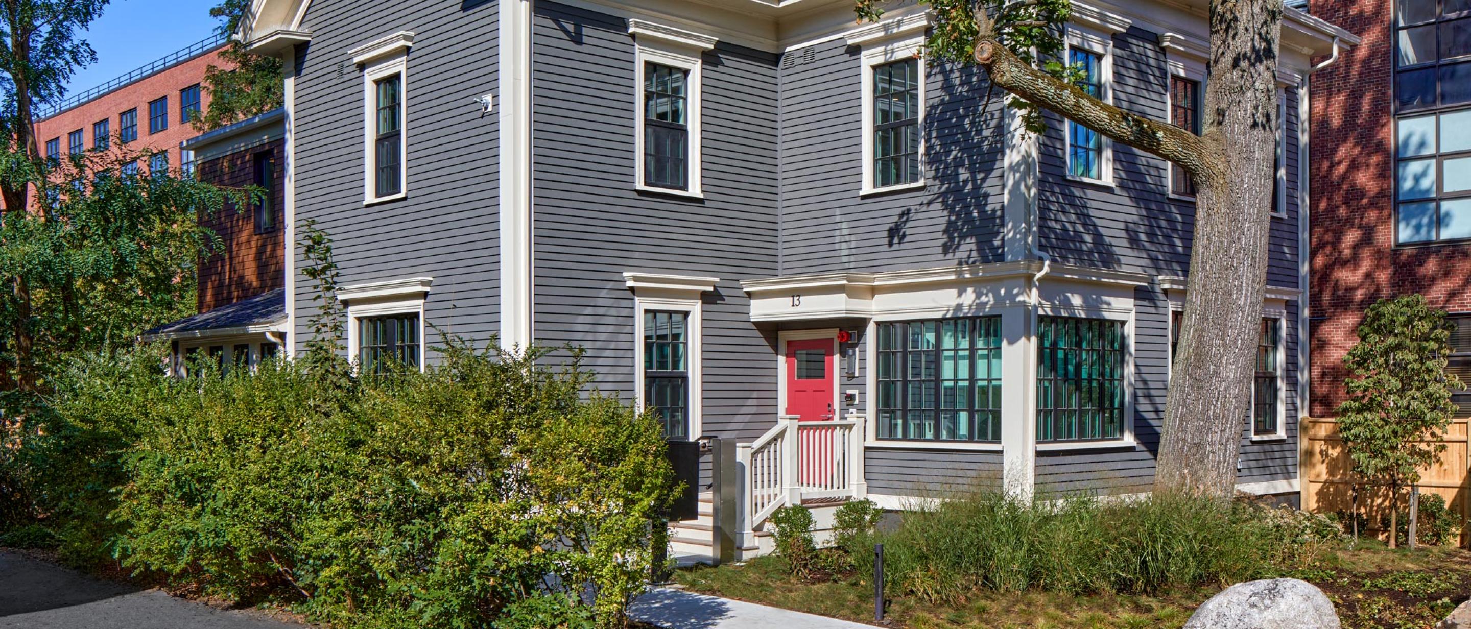 13 Kirkland: a newly renovated building with a bright red door and lush greenery