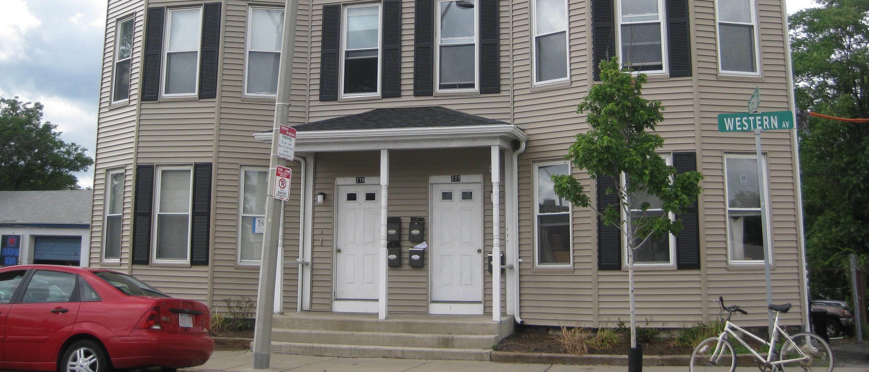 277-279 Western Avenue facing the street. Building has beige siding and dark shutters on alternating windows.