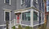 The front porch of 13 Kirkland, with white railings and a red front door