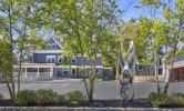 The view of 5 Sacramento through the trees and past the public art statue