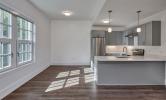 A sample kitchen in 13 Kirkland with sunny views and stainless steel appliances, recessed lighting, and pendant lighting over the kitchen island