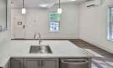 A sample kitchen in 13 Kirkland with sunny views and stainless steel appliances, recessed lighting, and pendant lighting over the kitchen island