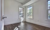 A sample bedroom in 13 Kirkland with sunny windows and hard flooring