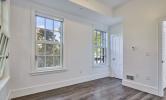 A sample bedroom in 13 Kirkland with sunny windows and hard flooring