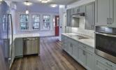 A sample kitchen in 13 Kirkland with sunny views and stainless steel appliances, recessed lighting, and pendant lighting over the kitchen island